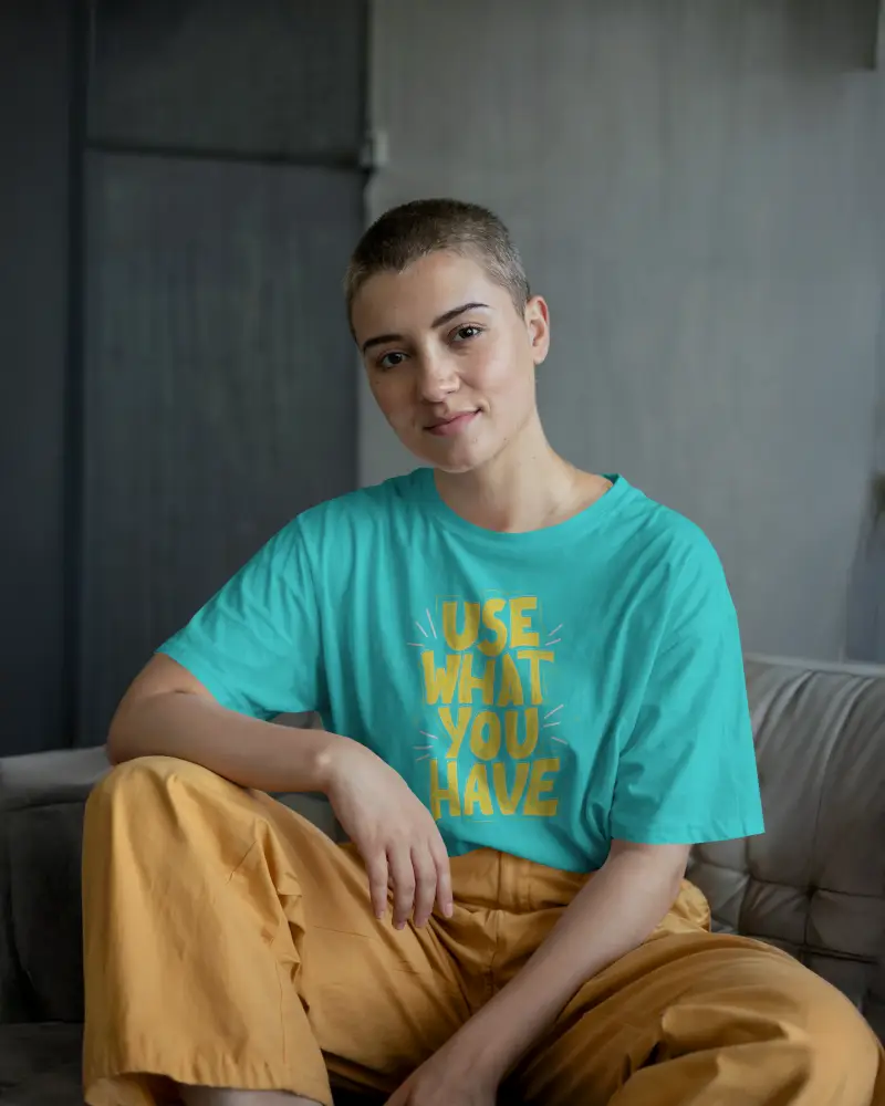 Tshirt Mockup Relaxed Female Model Sitting On Sofa In Loft Style Room Wearing White Shirt With Natural Lighting Casual Comfortable Ambience