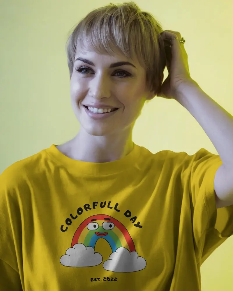 T Shirt Mockup Female Model Smiling With Blonde Short Hair Wearing Plain White Tee Against Yellow Background Modern And Optimistic Ambience