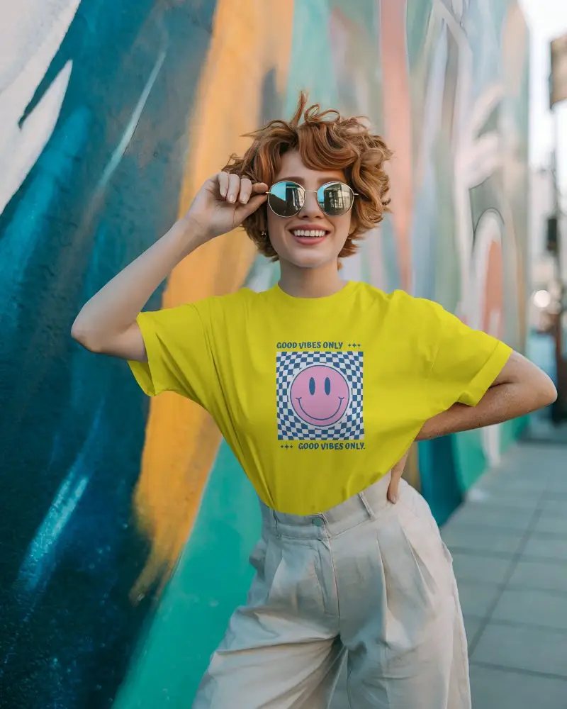 T Shirt Mockup Redhead Female Model Smiling In Sunglasses Against Bright Street Mural
