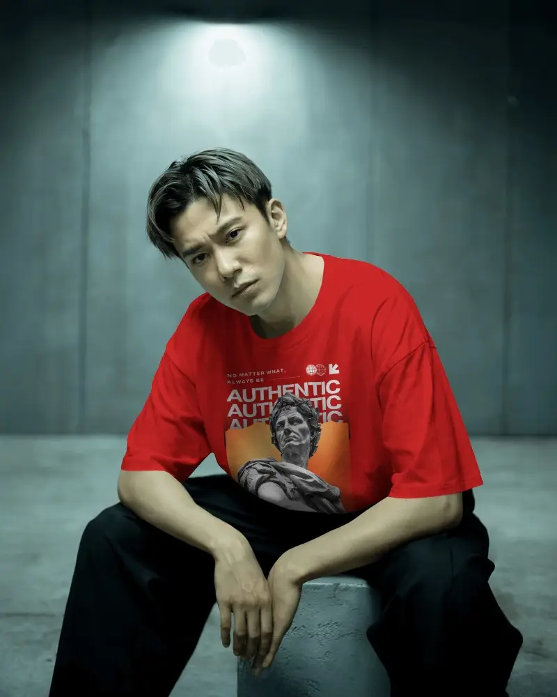 Moody Studio Tshirt Mockup Male Model Sitting On Concrete Block In Dramatic Spotlight