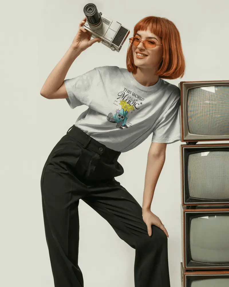 Retro Tshirt Mockup Female Model With Orange Glasses Holding Camera Beside Vintage Tvs