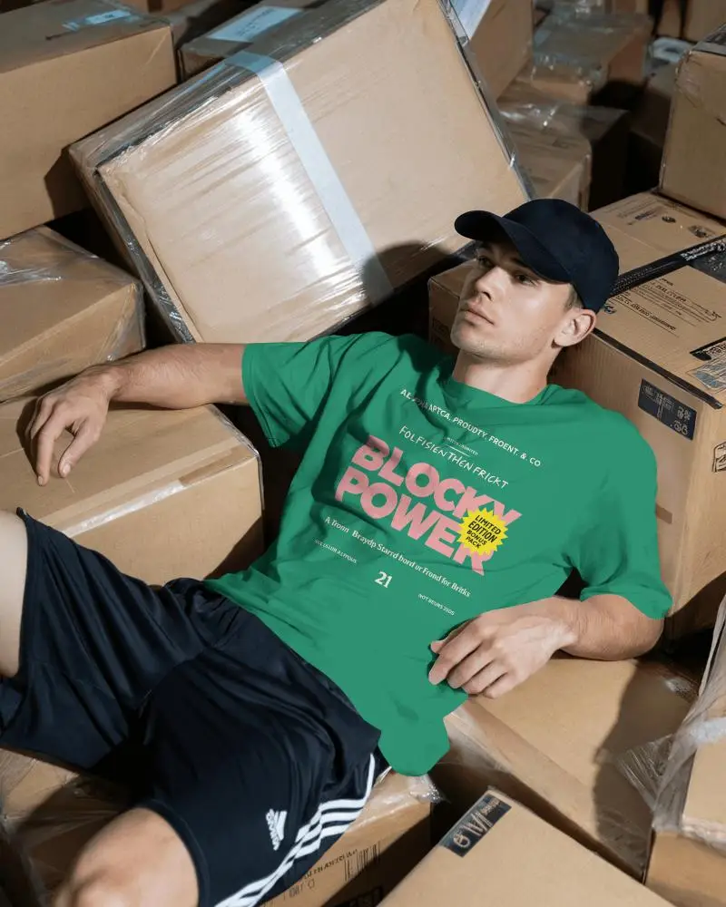 Warehouse Style T Shirt Mockup Male Model Relaxing Among Cardboard Boxes Casual Look