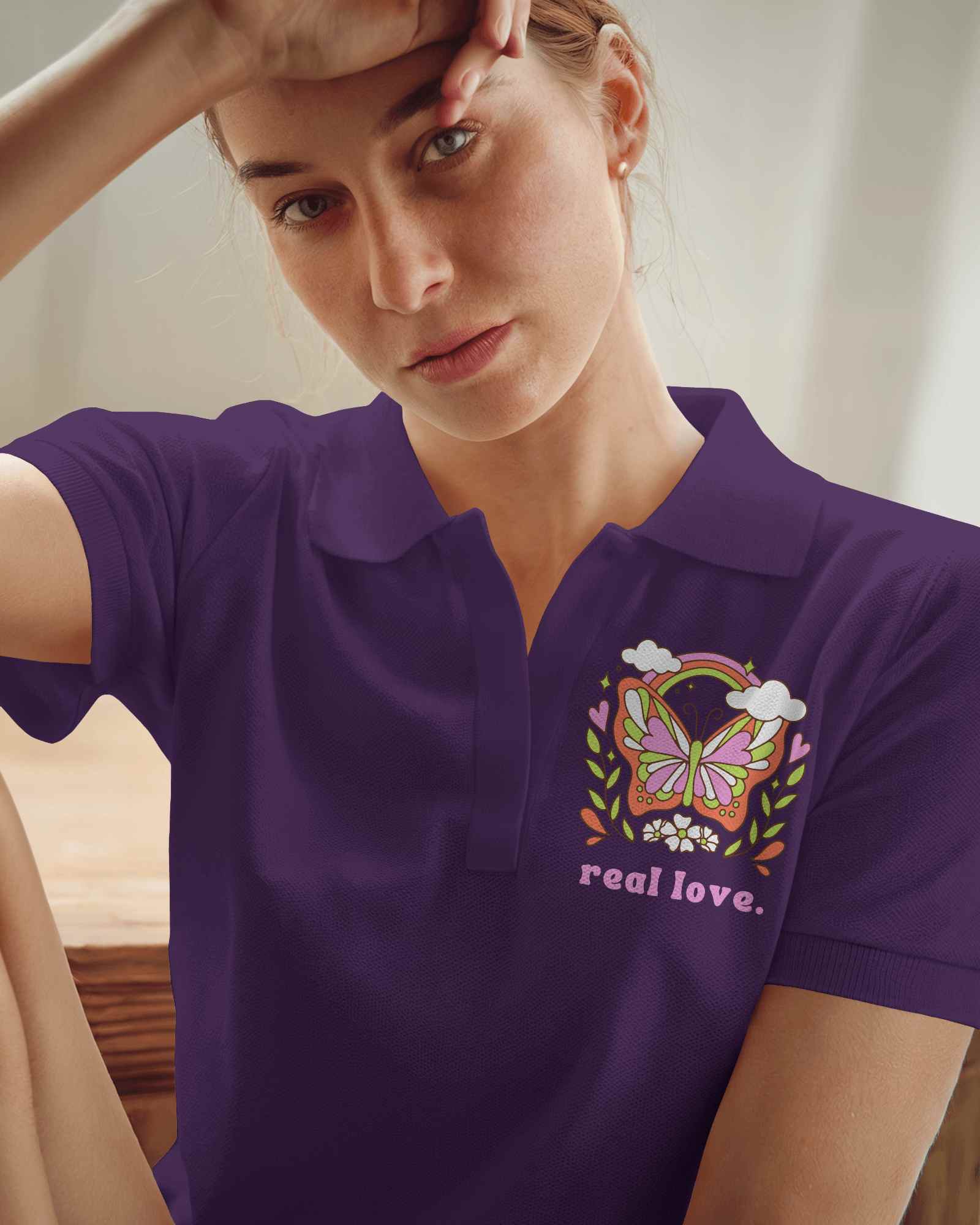 Relaxed Polo Shirt Mockup Female Model In Light Blue Polo With Daisy Design Casually Posing In Soft Natural Lighting Modern And Serene Look