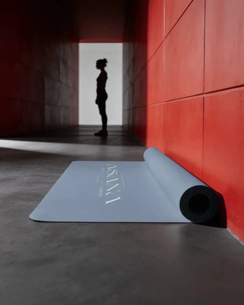 Rolled Yoga Mat Mockup In Red Corridor With Athlete Silhouette And Dramatic Gym Lighting