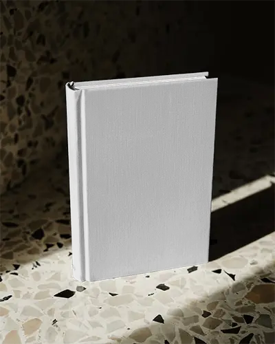 Hardcover Book Mockup Standing On Terrazzo Surface Under Dramatic Light Shadows