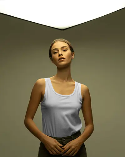soft-lit-studio-tank-top-mockup-female-model-standing-under-geometric-light-in-minimalist-environment