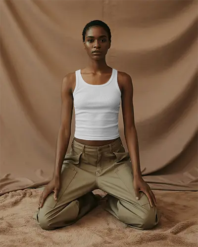 fashion-forward-tank-top-mockup-woman-wearing-fitted-top-and-cargo-pants-in-earth-toned-photo-studio