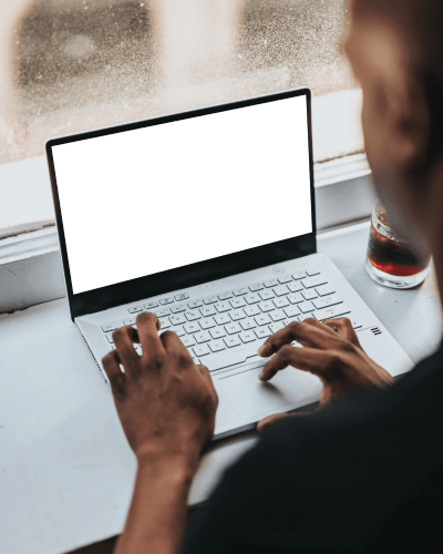 Laptop Mockup Near Window With User Typing And Drink On Side