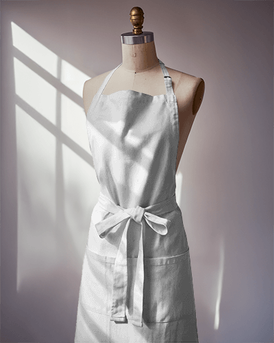 bold-red-apron-mockup-mannequin-display-good-vibes-graphic-sunny-window-lighting