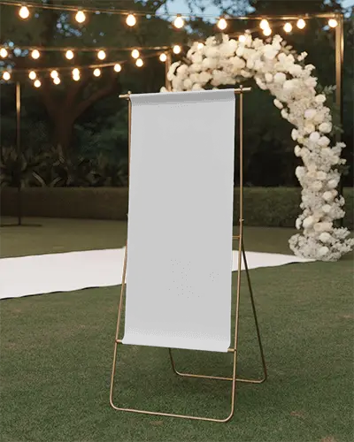Wedding Banner Mockup On Grass With Light Garland And Easel Stand In Decorative Evening Setting