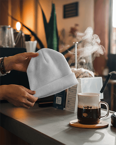 Good Vibes Beanie Mockup Neon Yellow Knit Hat With Happy Face Graphic Casual Cafe Setting With Warm Coffee Steam