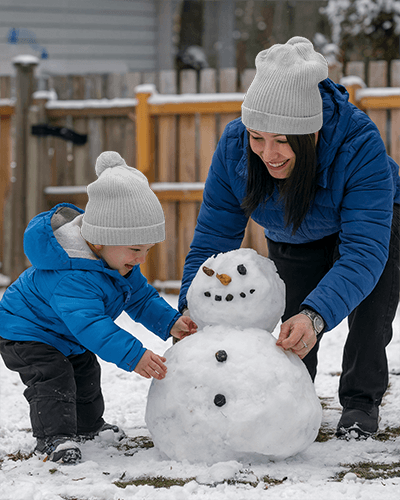 playful-snow-day-beanie-mockup-mother-and-toddler-in-blue-coats-enjoying-winter