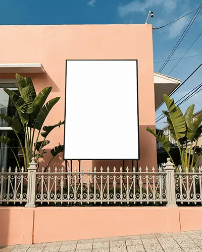 Street Vertical Billboard Mockup With Tropical Plants And Sunny Sky Vintage Metal Fence 