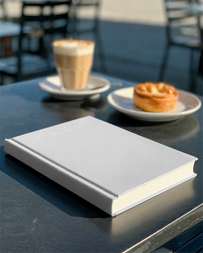 Outdoor Cafe Book Mockup On Metal Table With Coffee And Snack In Background Sunny Morning Scene
