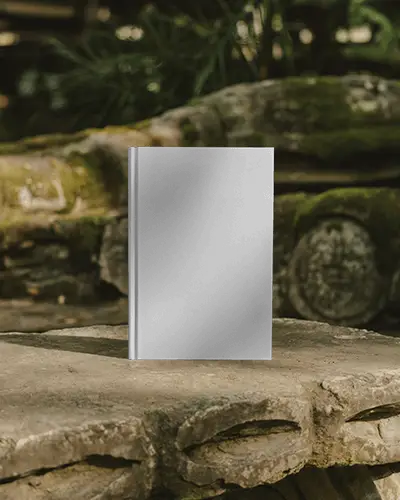 Hardcover Book Mockup On Weathered Stone Surface In Lush Natural Outdoor Setting
