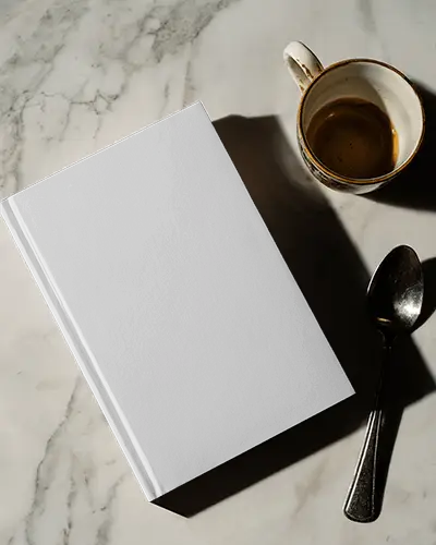 Top Down Book Mockup On White Marble Surface With Empty Espresso Cup And Spoon