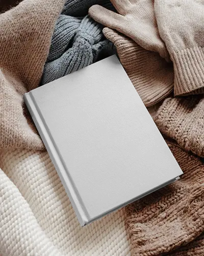 Ozy Winter Book Mockup Nestled In Knit Scarves And Gloves Soft Textile Surroundings