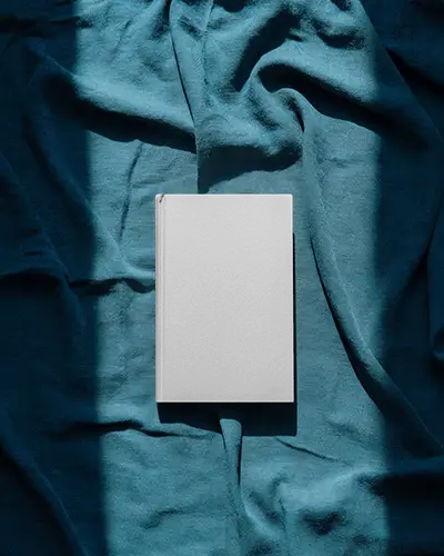 Top View Book Mockup On Teal Fabric Surface With Strong Contrasting Sunlight Shadow