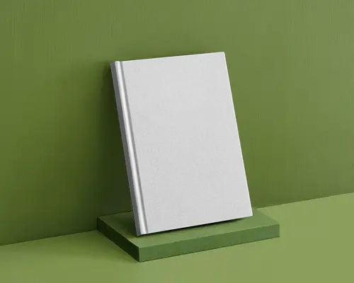 Leaning Book Mockup On Matte Green Podium With Tonal Green Background In Studio Shot