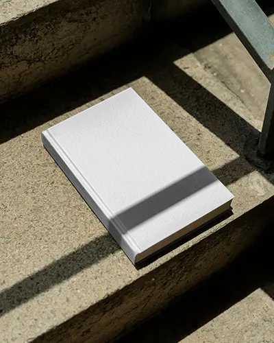 Angled Book Mockup Placed On Stone Steps With Harsh Shadows And Natural Sunlight