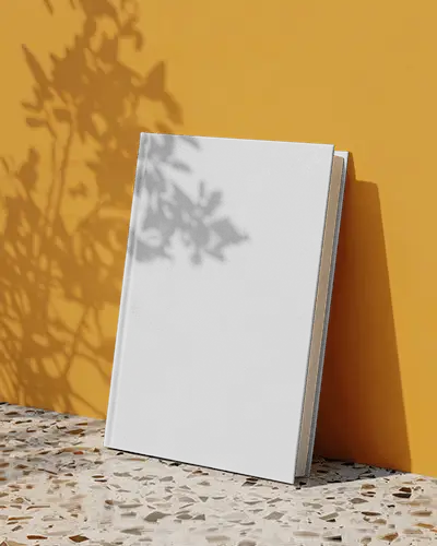 sunlit-book-mockup-leaning-on-yellow-wall-with-shadow-play-and-terrazzo-floor-detail