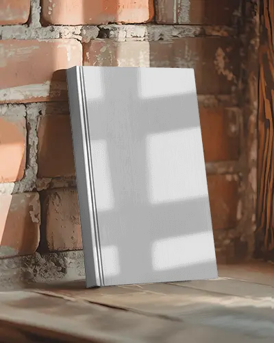 hardcover-book-mockup-standing-on-wooden-surface-against-textured-brick-wall-background