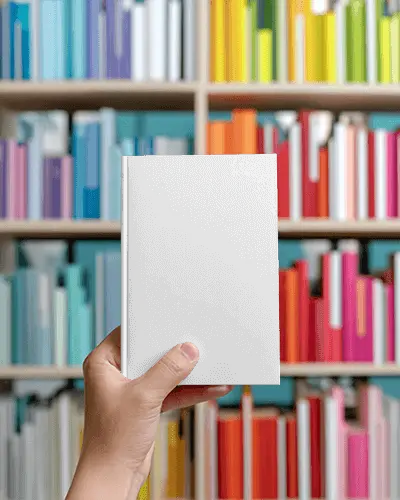 Hand Holding Blank Hardcover Book Mockup Against Colorful Library Bookshelf Background