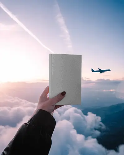Hand Holding Blank Book Mockup Against Sky And Airplane Background For Design Display