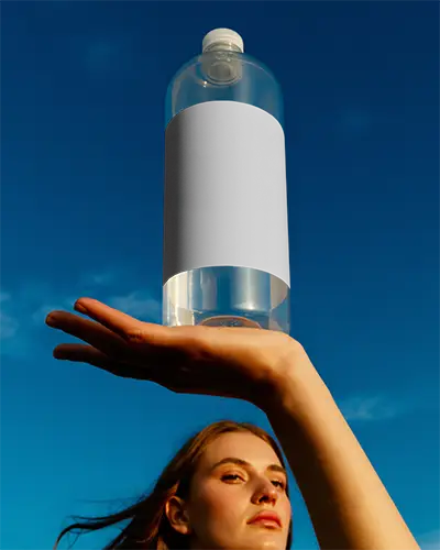 Hand Holding Blank Bottle Mockup Showcasing Label Design On Transparent Container