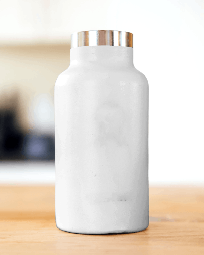 Minimalist White Metallic Bottle Mockup On Wooden Surface With Soft Background