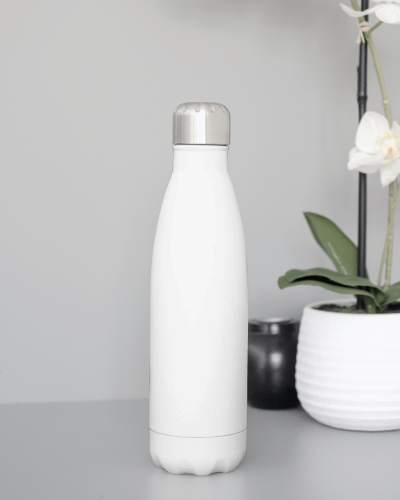 Sleek White Bottle Mockup On Neutral Surface With Minimal Decor And Floral Elements