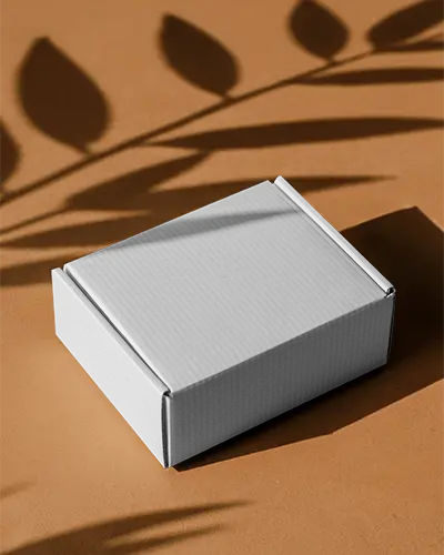 cardboard-box-mockup-on-brown-surface-with-leaf-shadows-for-organic-brand-packaging