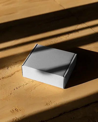 Premium Small Box Mockup On Wooden Surface With Long Sun Shadows In Warm Toned Lighting