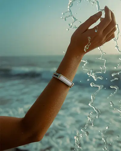 Sunlit Silver Bracelet Mockup On Wrist With Ocean Waves And Splashing Water