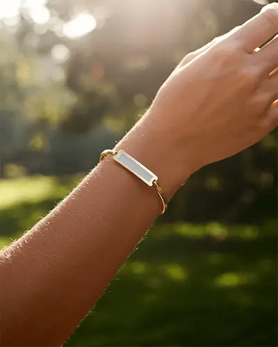Sunlit Gold Bracelet Mockup On Wrist In Natural Outdoor Light With Soft Green Background