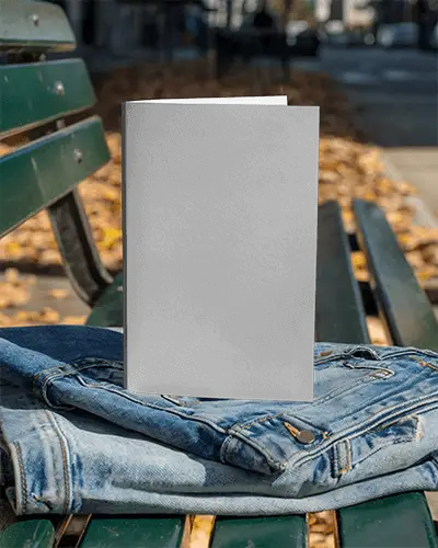 Vertical Brochure Mockup On Green Bench With Folded Denim Jacket In Autumn Park