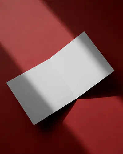 Open Brochure Mockup Half Fold Laying Flat On Red Surface With Dramatic Light And Shadow
