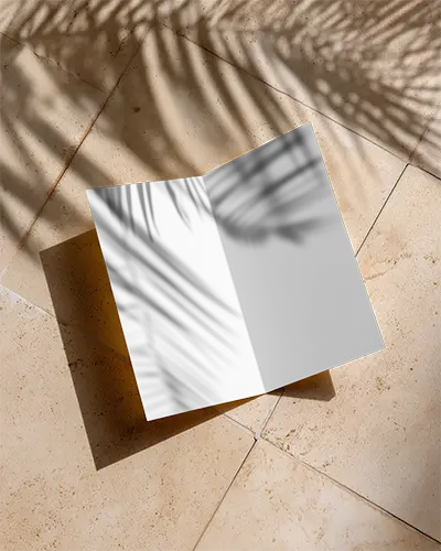 Top View Brochure Mockup Showcasing Clean Design And Shadow Play On Smooth Surface