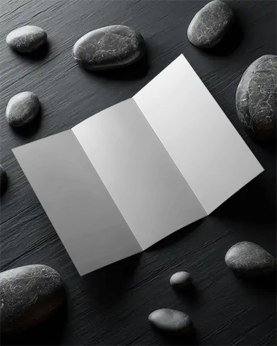 Three Panel Brochure Mockup On Wooden Texture With Smooth Stones Around Blank Design