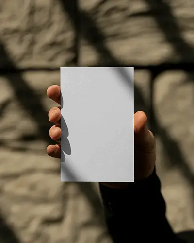 Closeup Hand Holding Vertical Business Card Mockup Natural Sunlight And Stone Texture Scene