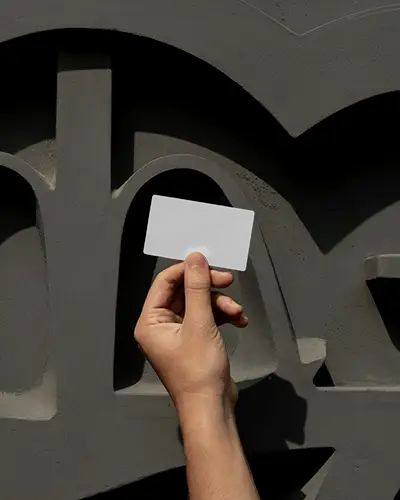 Hand Holding Business Card Mockup Against Architectural Wall With Modern Style
