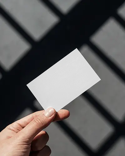 Hand Holding Business Card Mockup Against Grid Shadow Background Clean Modern Look