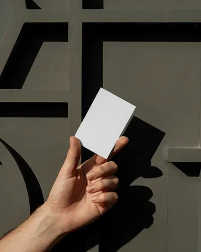 Hand Holding Business Card Mockup Against Textured Stone Wall Clean Modern Look