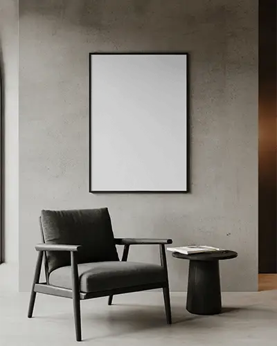 framed-canvas-mockup-on-concrete-wall-with-minimal-black-chair-round-side-table-and-book