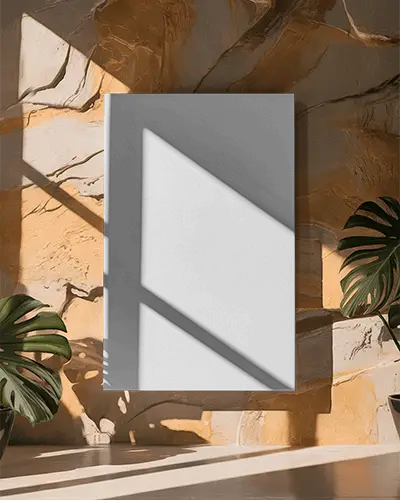 vertical-canvas-mockup-against-stone-wall-with-dramatic-sunlight-and-green-monstera-plants