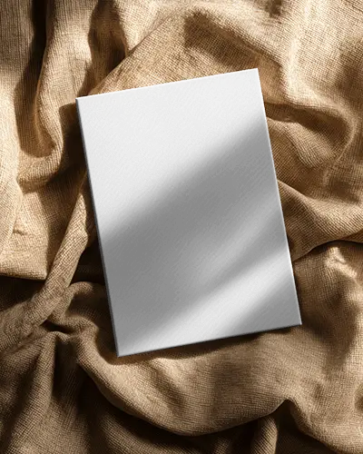 Flatlay Canvas Mockup On Textured Brown Fabric With Soft Light