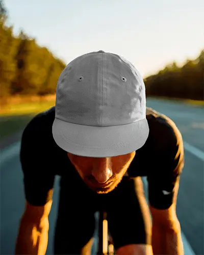 Sunset Road Cycling Cap Mockup Worn By Rider In Motion With Trees Casting Golden Light Glow