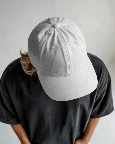 casual-baseball-cap-mockup-male-model-looking-down-in-dark-oversized-shirt-minimal-studio-scene