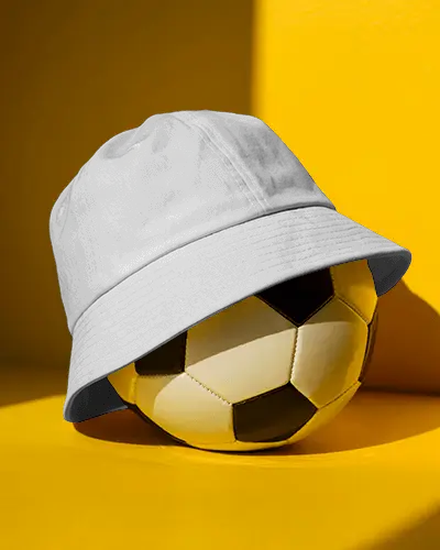 sporty-bucket-hat-mockup-dark-cap-on-soccer-ball-bright-yellow-background-athletic-display