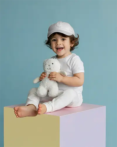 Smiling Toddler Cap Mockup With Holding Cuddly Plush Toy Seated On Colorful Block